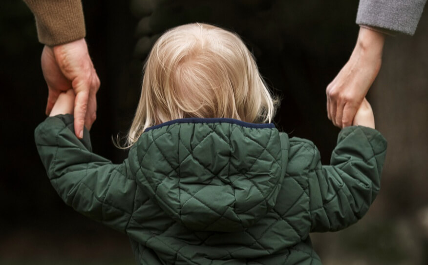 Parents holding their child's hands